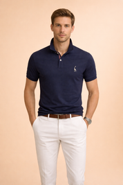 Classic navy short-sleeve polo shirt with structured collar, two-button placket and subtle embroidered chest logo, styled with tailored white trousers and a brown leather belt for a clean, refined look