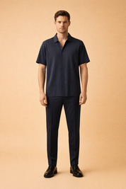 Luxury navy two-piece men’s outfit featuring a short-sleeve collared shirt with smooth matte fabric, clean front placket, and tailored straight-leg trousers in a matching deep navy tone with crisp seams and refined drape, styled as a modern minimalist formal set