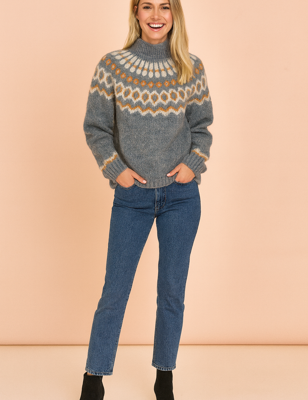 Nordic-patterned heather gray knitted sweater with cream and mustard geometric yoke design, paired with blue straight-leg jeans and black ankle boots.