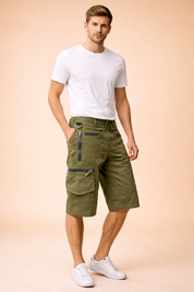 Olive green military-style cargo shorts with a structured cotton-blend fabric, featuring reinforced stitching, multiple utility pockets with metal zippers and flap closures, adjustable waistband detailing, and a straight knee-length cut, paired with a solid royal blue short-sleeve crew-neck T-shirt in smooth jersey cotton and clean white low-top athletic sneakers with layered mesh and rubber soles.