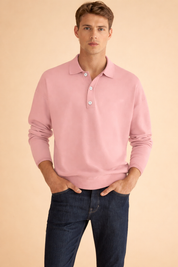 Soft pink long-sleeve polo shirt with classic collar and three-button placket, paired with dark blue straight-leg denim jeans in a clean, tailored fit.