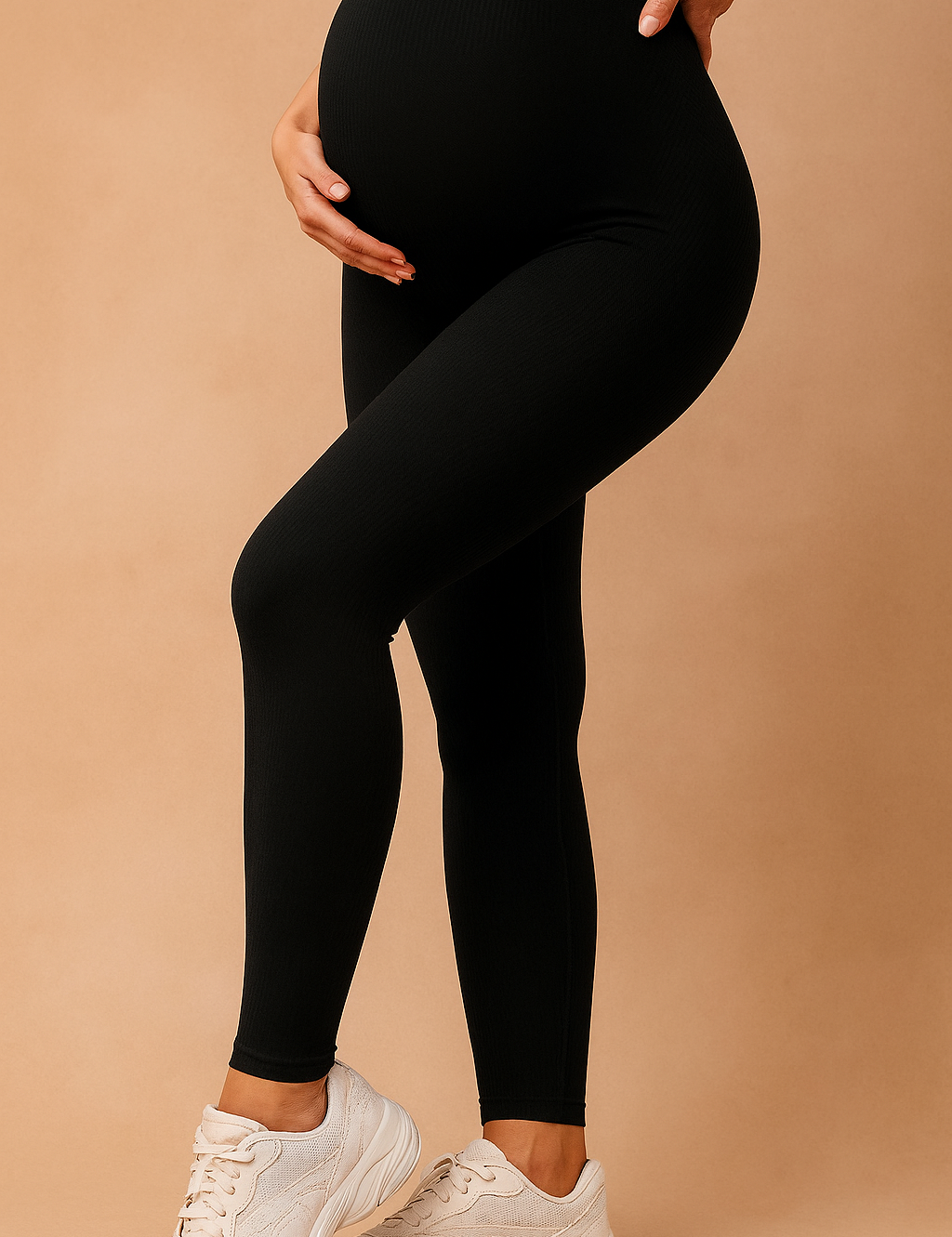 High-waisted black ribbed maternity leggings styled with white sneakers, designed for support and comfort during pregnancy.