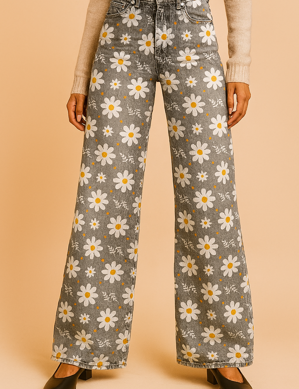 High-waisted wide-leg jeans in faded gray with a white daisy floral print and light distressing, styled with front pockets, belt loops, and black heeled shoes.