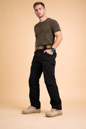 Men’s tactical cargo trousers with straight-leg cut, reinforced knee panels, zippered thigh pockets, side cargo flap pockets, structured waistband with belt, and durable outdoor footwear styling.