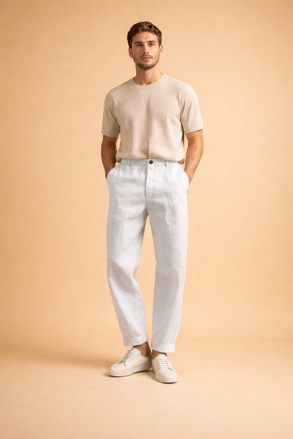 Men’s tailored green trousers with a relaxed straight-leg cut, front pleat detail, cuffed hems, and clean waistband styling, paired with minimalist white low-top sneakers for a refined modern look.