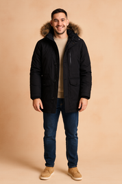 Black winter parka jacket with fur-lined hood, button and zipper closure, and multiple front pockets, styled with a beige sweater, jeans, and suede boots.