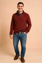 Quarter-zip ribbed sweater in deep burgundy layered over a plaid shirt, styled with classic blue jeans for a warm, casual winter look