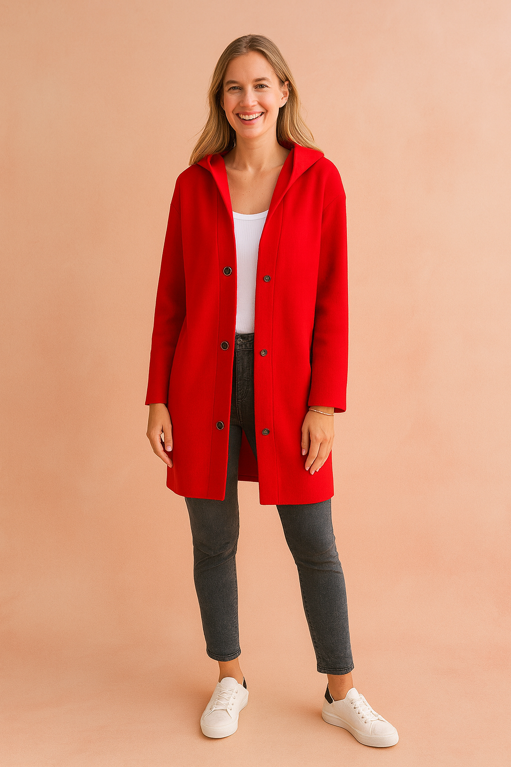 Vibrant red longline button-up jacket with black snap buttons, paired with a white top, charcoal skinny jeans, and white sneakers.