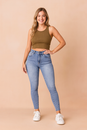 Light blue high-waisted skinny jeans with a faded wash design, paired with classic white sneakers