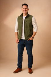 Men’s olive green zippered vest paired with a white long-sleeve shirt and dark blue jeans, featuring multiple front zipper pockets and a sleek casual design