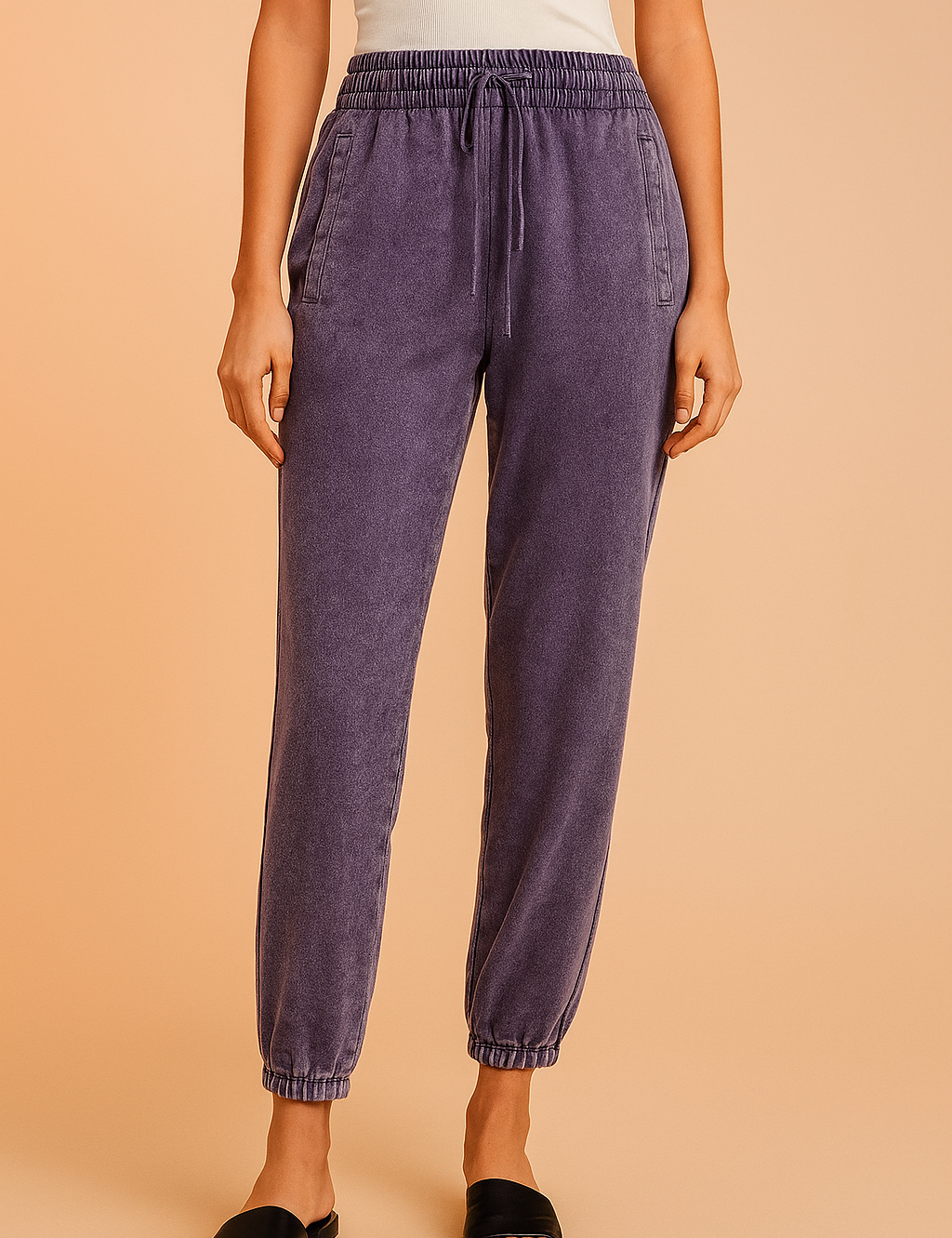 Purple jogger pants with a soft washed finish, featuring an elastic waistband with drawstring, slanted front pockets, and elasticated cuffs for a tapered fit.