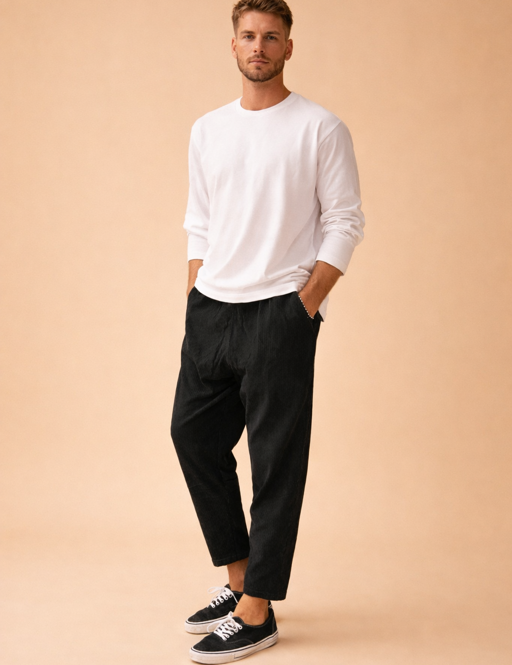 Black tapered ankle-length trousers with a clean straight finish, styled with a minimalist long-sleeve top and low-profile lace-up sneakers for a modern casual outfit.