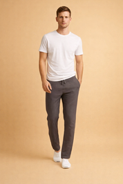Slim-fit charcoal gray lightweight drawstring trousers with a tapered ankle-length cut, paired with a clean white short-sleeve crew-neck T-shirt and minimalist white low-top sneakers.
