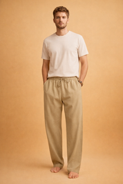 Light blue linen trousers with a relaxed straight-leg cut, elasticated waistband with adjustable drawstring, smooth breathable fabric texture, and clean full-length drape paired with a minimalist white short-sleeve crew-neck T-shirt.