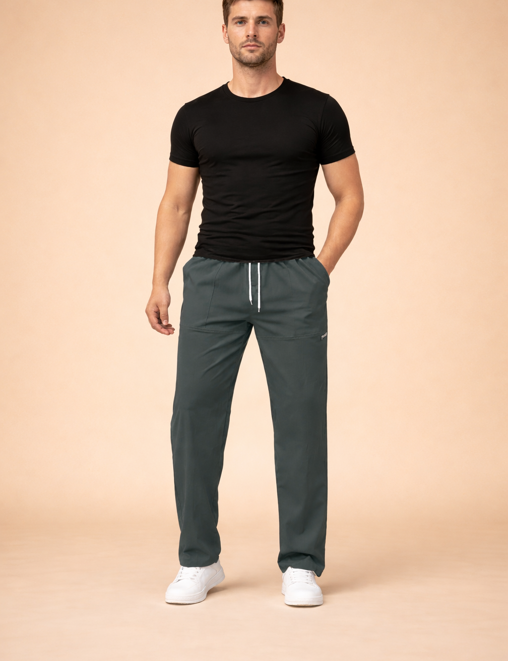 Men’s relaxed-fit drawstring trousers with elastic waistband, straight-leg cut, clean front seam detailing, subtle side logo accent, and minimal sporty-casual silhouette styled with low-profile sneakers.