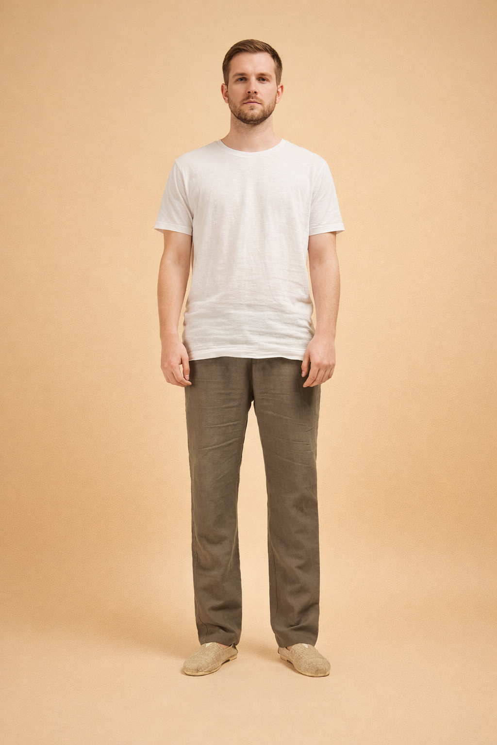 Men’s straight-leg trousers with a relaxed tailored cut, smooth front, clean waistband, and full-length legs, styled with a minimal top and neutral slip-on footwear for a refined everyday look.