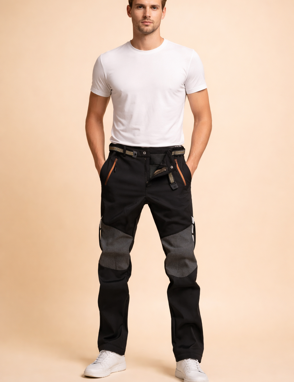 Men’s technical slim-fit trousers with reinforced knee panels, zippered front pockets, adjustable waist belt, straight leg cut, and structured utility detailing for a modern performance look.