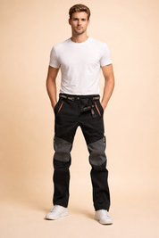 Men’s technical slim-fit trousers with reinforced knee panels, zippered front pockets, adjustable waist belt, straight leg cut, and structured utility detailing for a modern performance look.