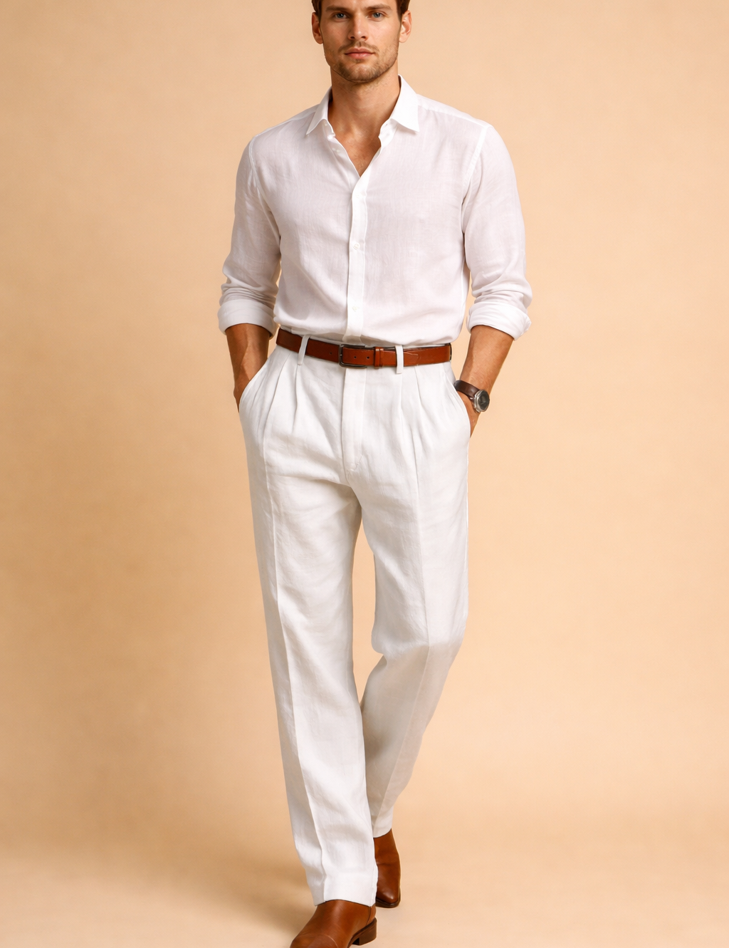 Tailored white pleated trousers with a straight-leg cut, mid-rise waist, clean front pleats, belt loops, and a refined drape, styled with a tucked-in white long-sleeve shirt, brown leather belt, and brown leather loafers.