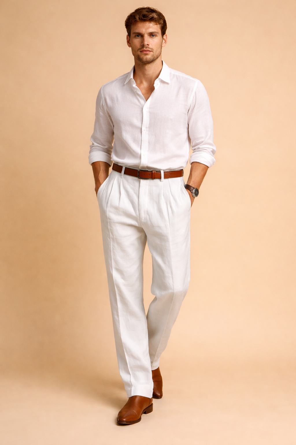 Tailored white pleated trousers with a straight-leg cut, mid-rise waist, clean front pleats, belt loops, and a refined drape, styled with a tucked-in white long-sleeve shirt, brown leather belt, and brown leather loafers.