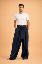 Loose-fit wide-leg trousers with a high gathered waist, wrap-tie belt detail, flowing drape, and full-length cut designed for a relaxed yet refined silhouette.