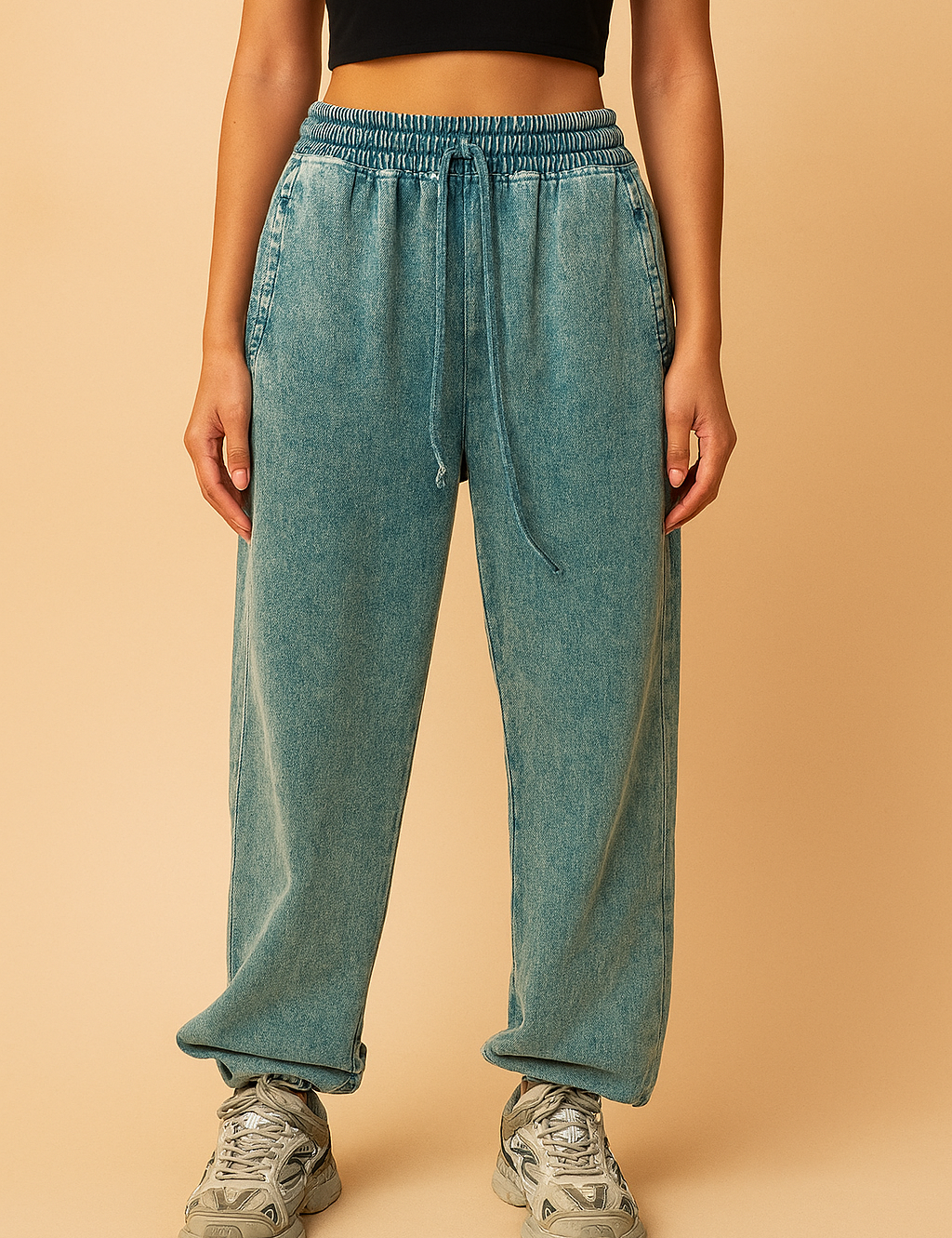 Relaxed-fit teal acid-wash jogger sweatpants featuring an elastic waistband with drawstring, straight leg silhouette, and rolled cuffs, paired with chunky gray athletic sneakers.