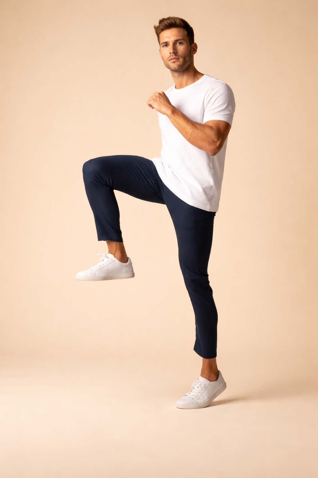 Slim-fit navy blue tapered pants with a clean ankle-length cut, paired with minimalist white low-top sneakers for a modern, streamlined look.
