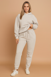 Light grey fleece hoodie and matching jogger sweatpants set made from soft brushed cotton with a relaxed fit, featuring elastic cuffs, an adjustable drawstring waistband, and a cozy hood.