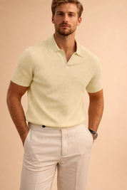 Short-sleeve ribbed knit polo top with an open collar neckline, tailored slim fit, clean hem finish, and minimalist design paired with structured straight-leg trousers for a refined modern look.