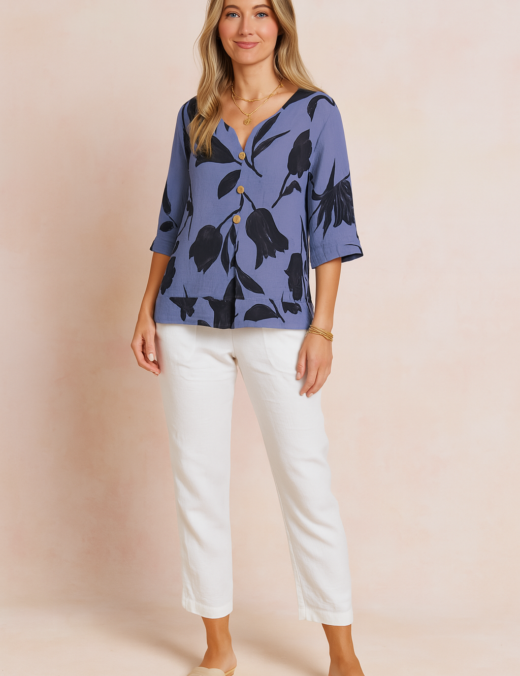 Button-front slate blue blouse with large black tulip floral print, featuring a relaxed fit, V-neckline, and three-quarter sleeves, styled with white linen trousers.