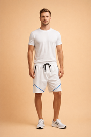 White athletic shorts with smooth lightweight fabric, elastic waistband with black drawstring, zippered side pockets, and precise blue geometric accent lines, paired with a clean white fitted short-sleeve T-shirt and white low-profile sneakers for a minimalist sport-luxury look.