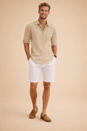 White long-sleeve open-placket top with a clean collarless neckline, styled with straight-fit white trousers and tan suede loafers for a crisp, elevated resort-inspired look.