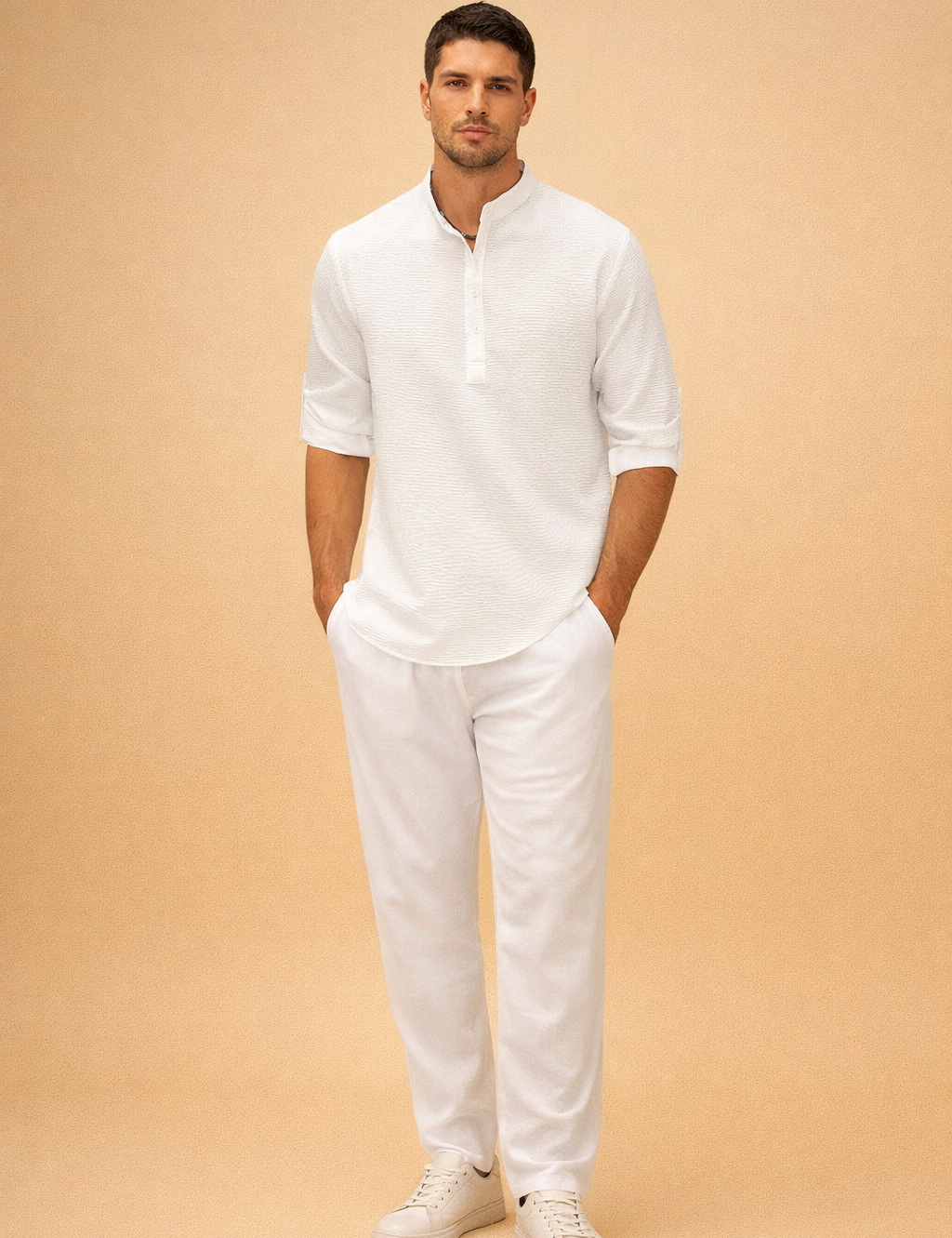 Textured white long-sleeve henley shirt with subtle woven fabric pattern, band collar and button placket, paired with relaxed-fit white trousers and clean minimalist white low-top sneakers for a refined summer casual look.