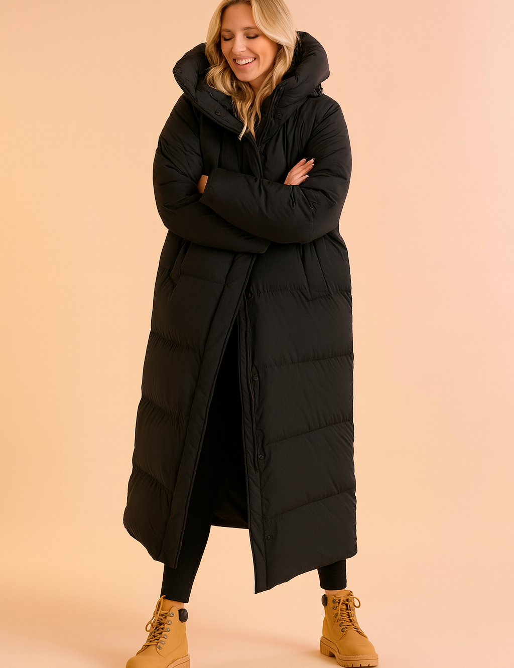 Women's long black puffer down jacket with oversized hood, quilted padding, full-length design, button-up closure, side pockets, paired with black leggings and tan lace-up boots